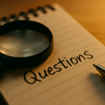 Handwritten note reading “Questions” under a magnifying glass—symbolizing inquiry