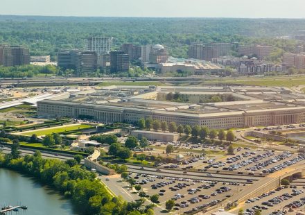 The pentagon building with surrounding parking lot and trees.