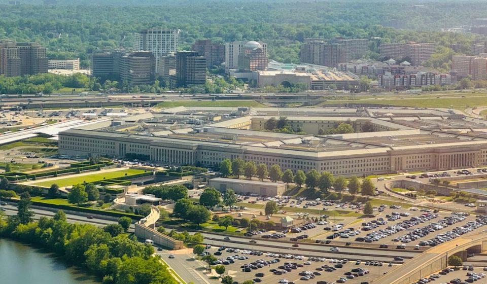 The pentagon building with surrounding parking lot and trees.