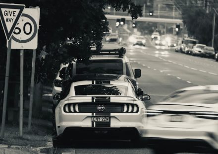 Traffic on an Australian urban road beside give way and speed limit signs