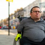 Man using a wheelchair on a city street, representing the population studied in a CBD neuropathic pain trial