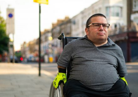 Man using a wheelchair on a city street, representing the population studied in a CBD neuropathic pain trial