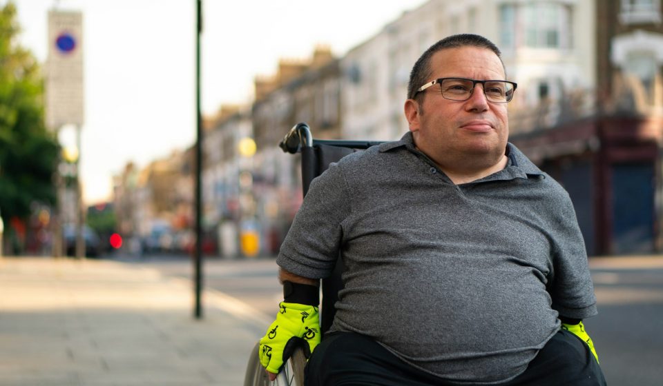 Man using a wheelchair on a city street, representing the population studied in a CBD neuropathic pain trial